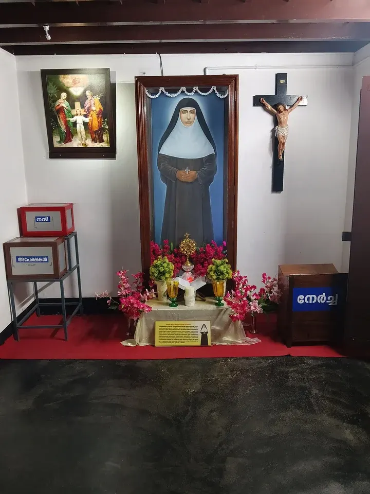 Mariam Thresia Chiramel Mankidiyan: photograph of a shrine with a large nun's portrait, flowers and a crucifix
