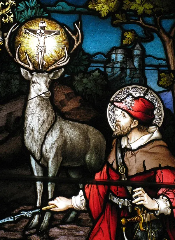 Hubert of Liège: stained-glass hunter kneeling before a stag with a crucifix between its antlers