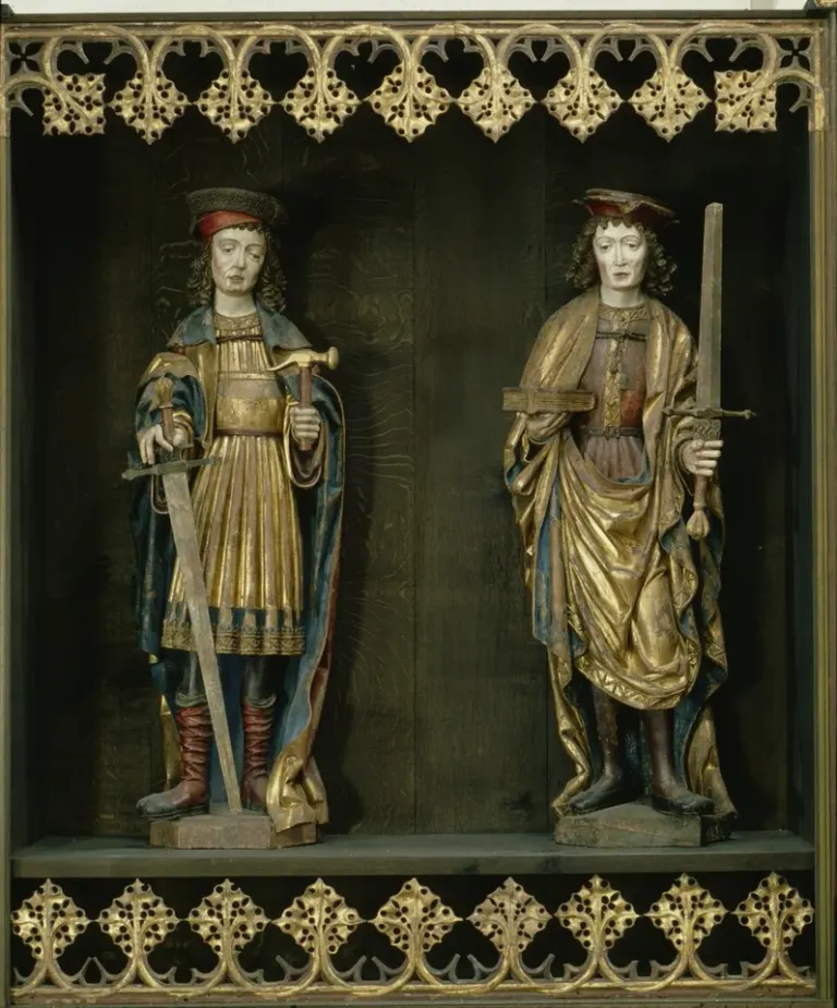 Crispin: two carved figures standing beneath an ornate canopy