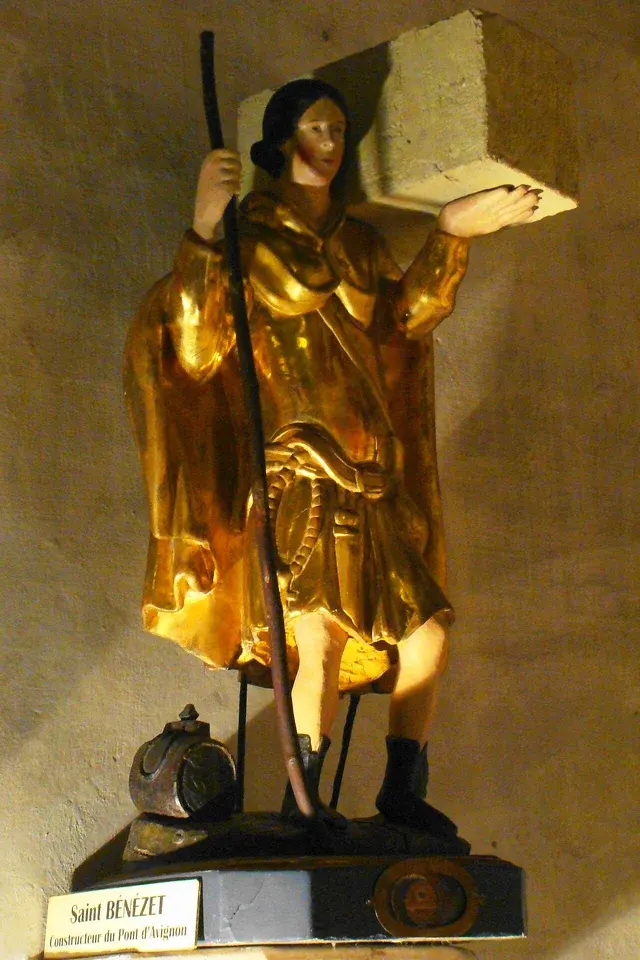 Bénézet: gilded statue of a young man carrying a large stone
