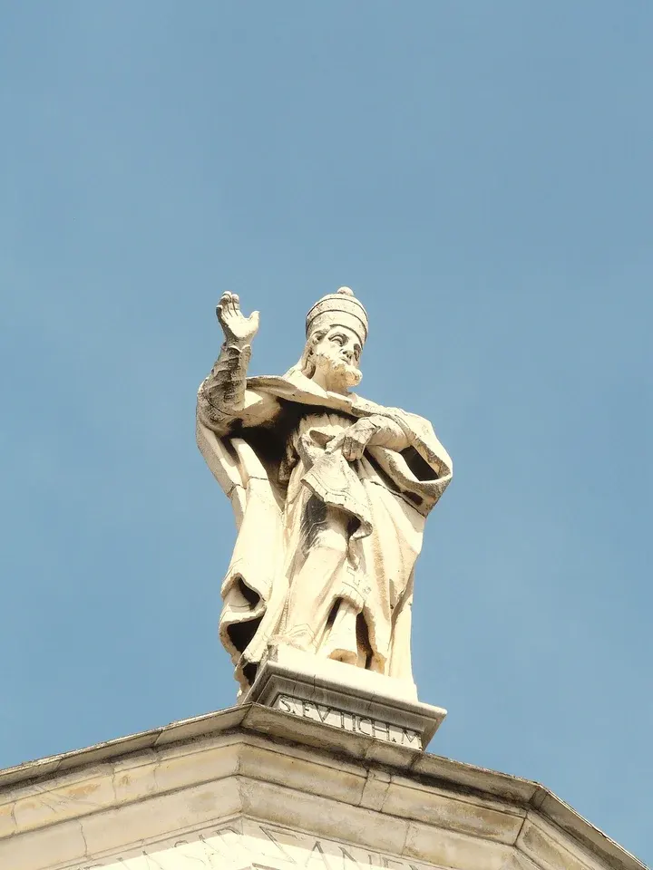 Eutychian: stone statue of a pope above a church roofline