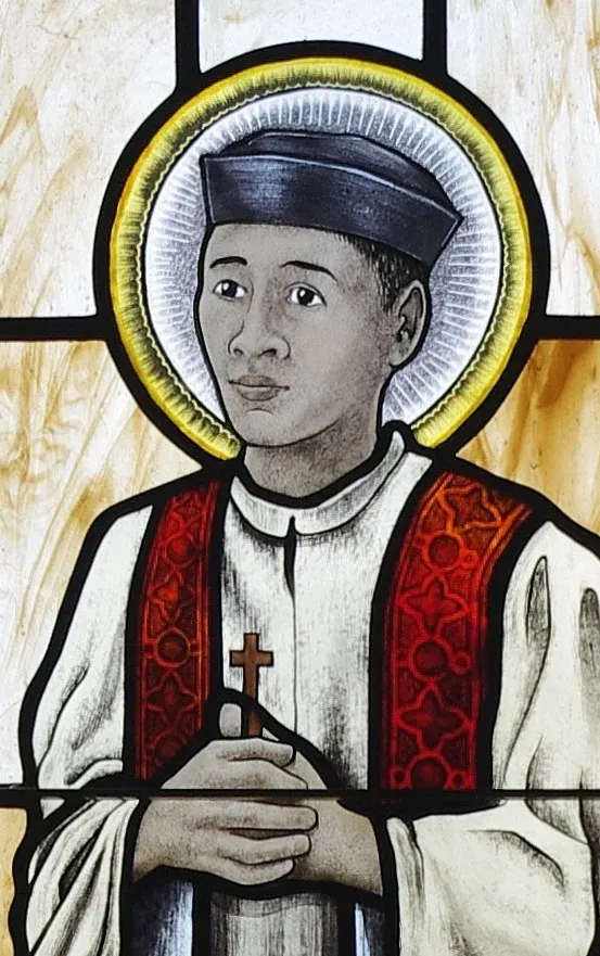 Andrew Dũng Lạc: stained-glass priest in a dark cap holding a cross