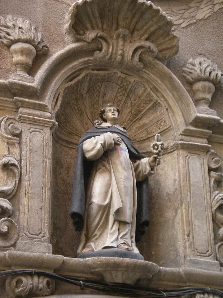 Michael of the Saints: stone statue of a cleric in an ornate wall niche